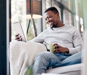 A man smiling at is tablet